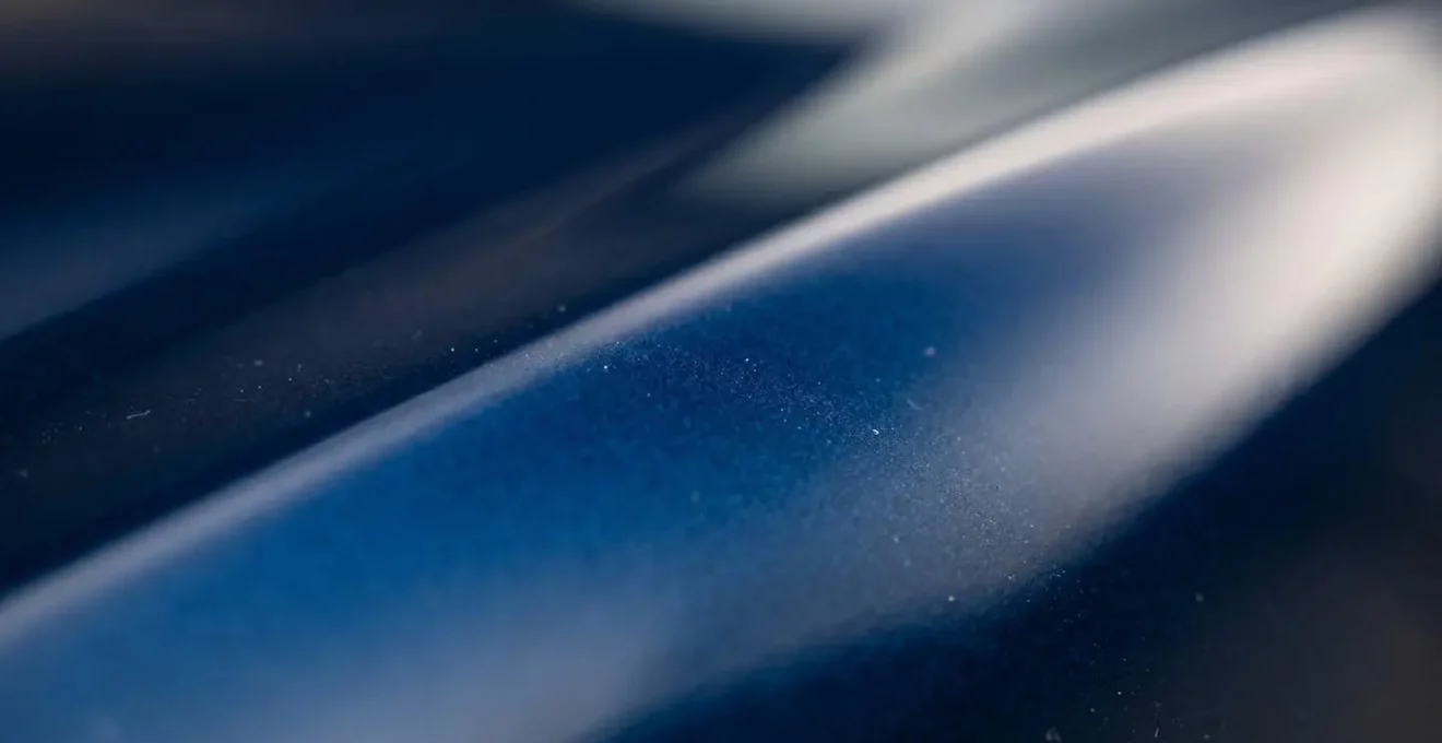 Détail macro de la carrosserie brillante d'une voiture neuve montrant la qualité de finition